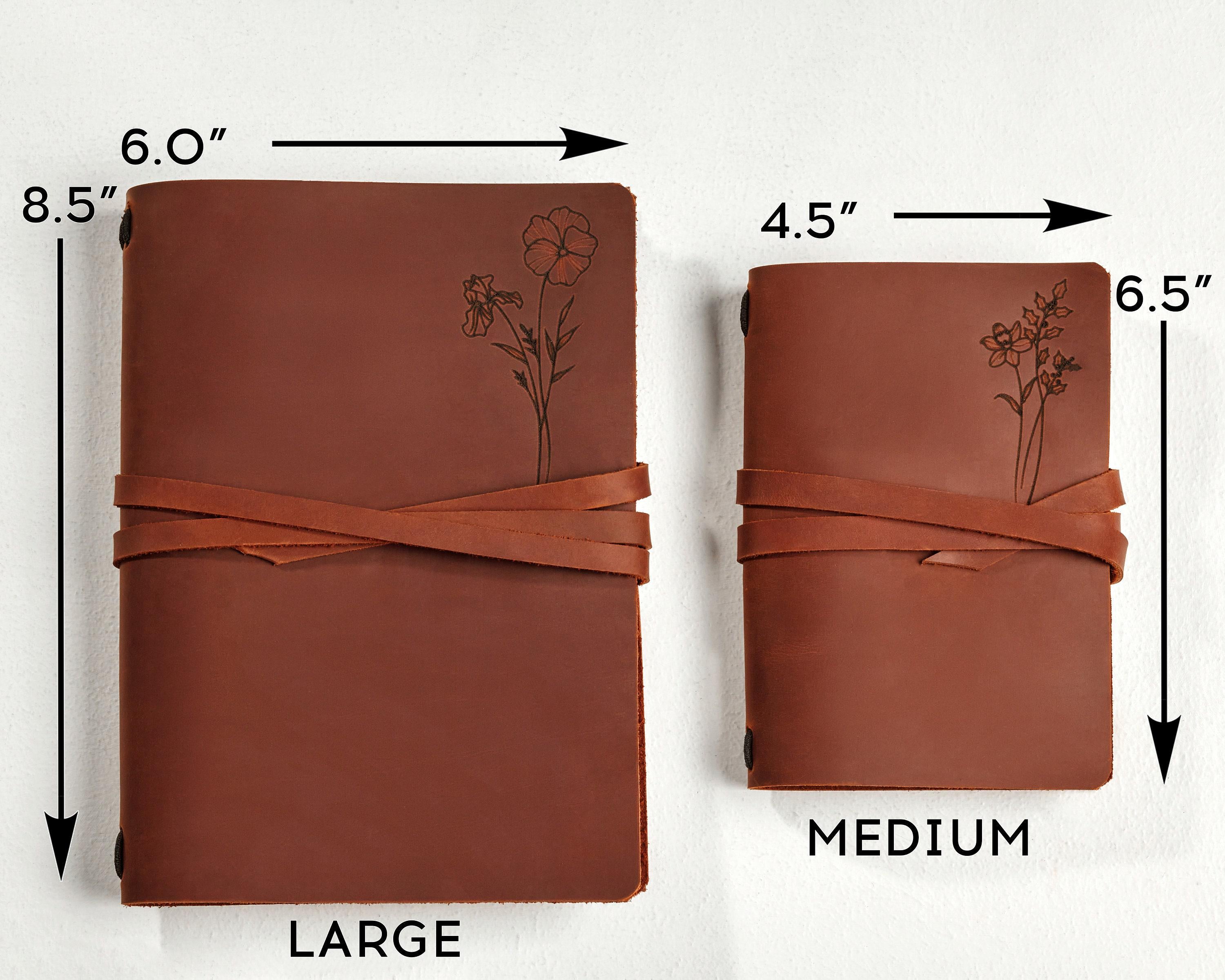 a brown leather notebook with a flower drawn on it